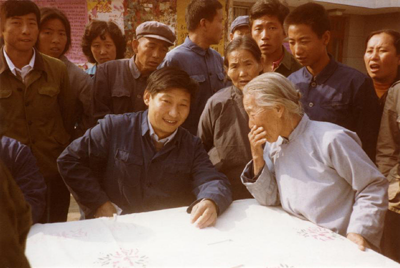 1983年，時(shí)任河北正定縣委書(shū)記的習近平（前排居中），臨時(shí)在大街上擺桌子聽(tīng)取老百姓意見(jiàn)。